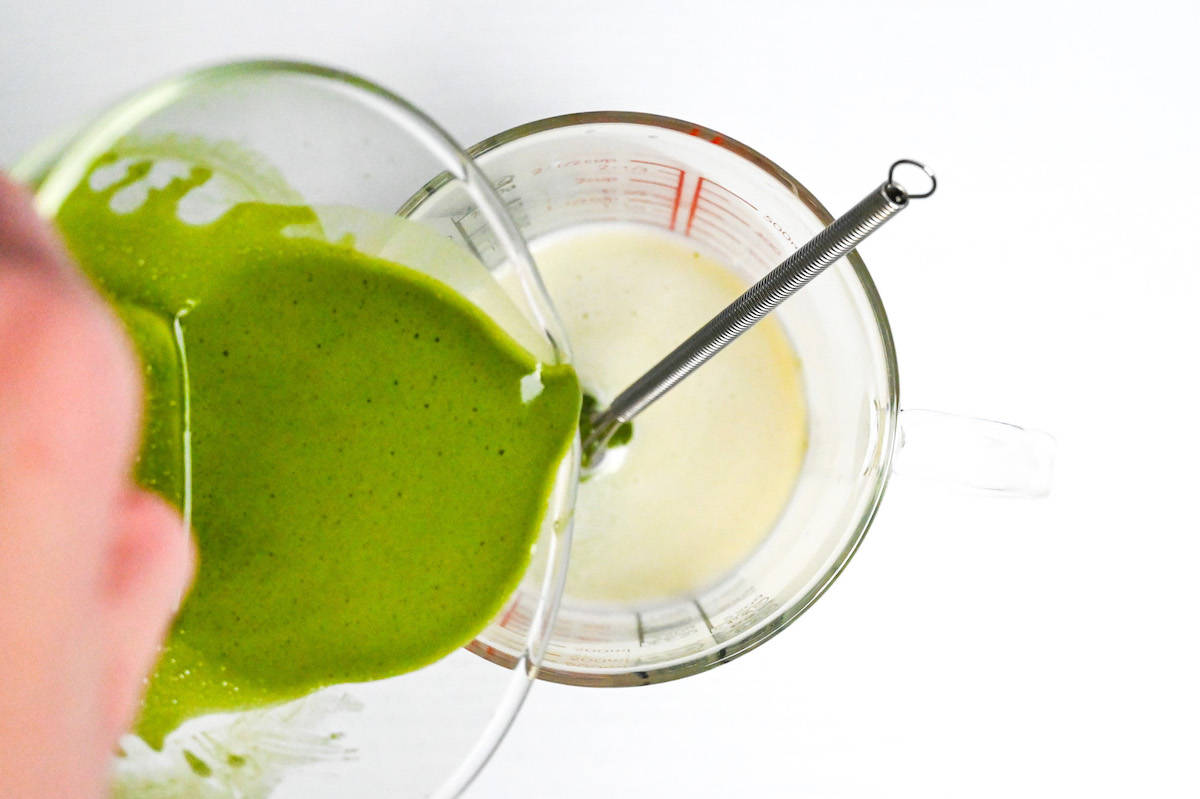 pouring matcha into heated milk and chocolate mixture