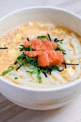 Mentaiko ankake udon served in a cream bowl and topped with shiso leaves. featured image