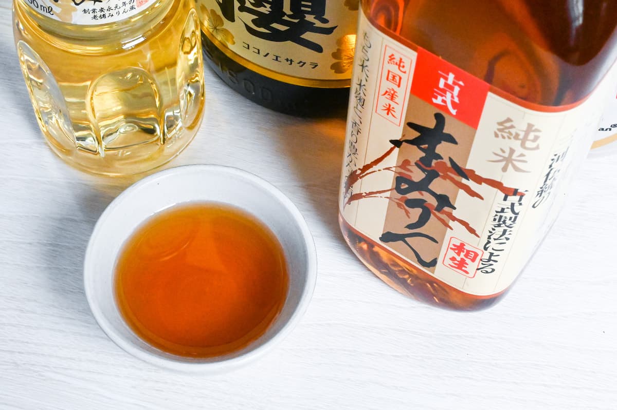 Bottles of Japanese hon mirin (Sweet rice wine seasoning) with some poured in a small white bowl