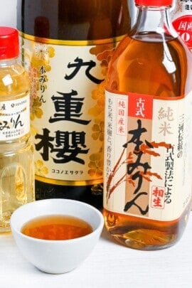 Bottles of Japanese hon mirin (Sweet rice wine seasoning) with some poured in a small white bowl