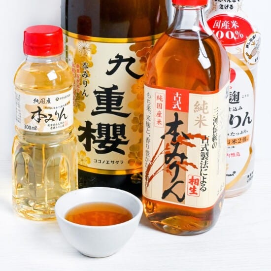 Bottles of Japanese hon mirin (Sweet rice wine seasoning) with some poured in a small white bowl