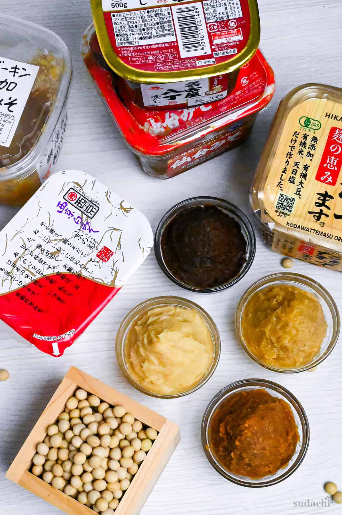 various brands and types of miso paste on a white wood-effect background