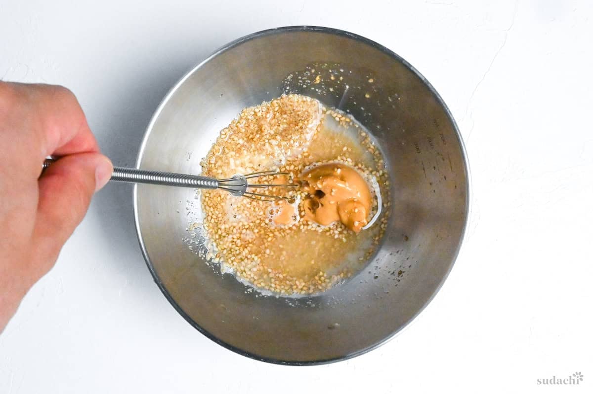 whisking ground sesame seeds, chicken bouillon powder and peanut butter with water