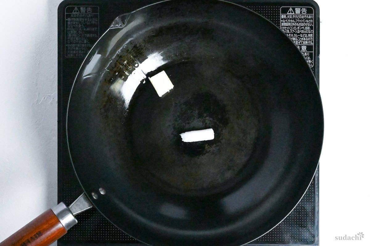 butter and lard melting in a wok on the stove