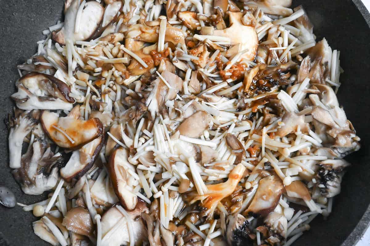 a close up of pan-fried mushrooms coated in sauce in a frying pan