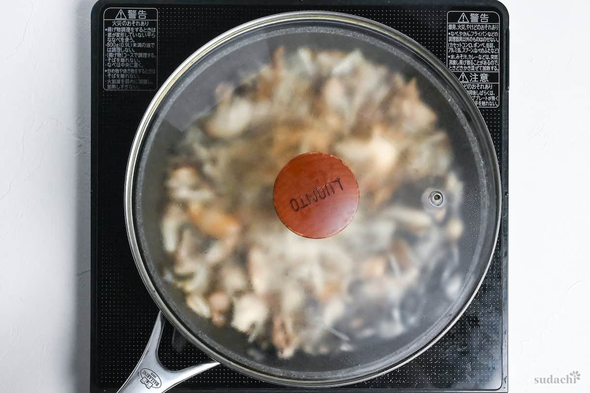 mushrooms in a frying pan covered with lid on the stove top