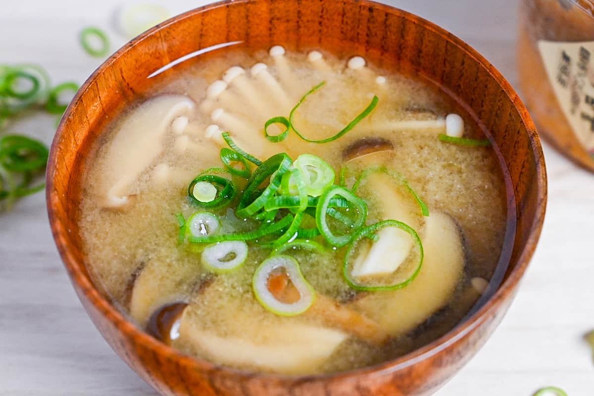 Mushroom miso soup made with 4 kinds of mushroom served in a wooden bowl side close up
