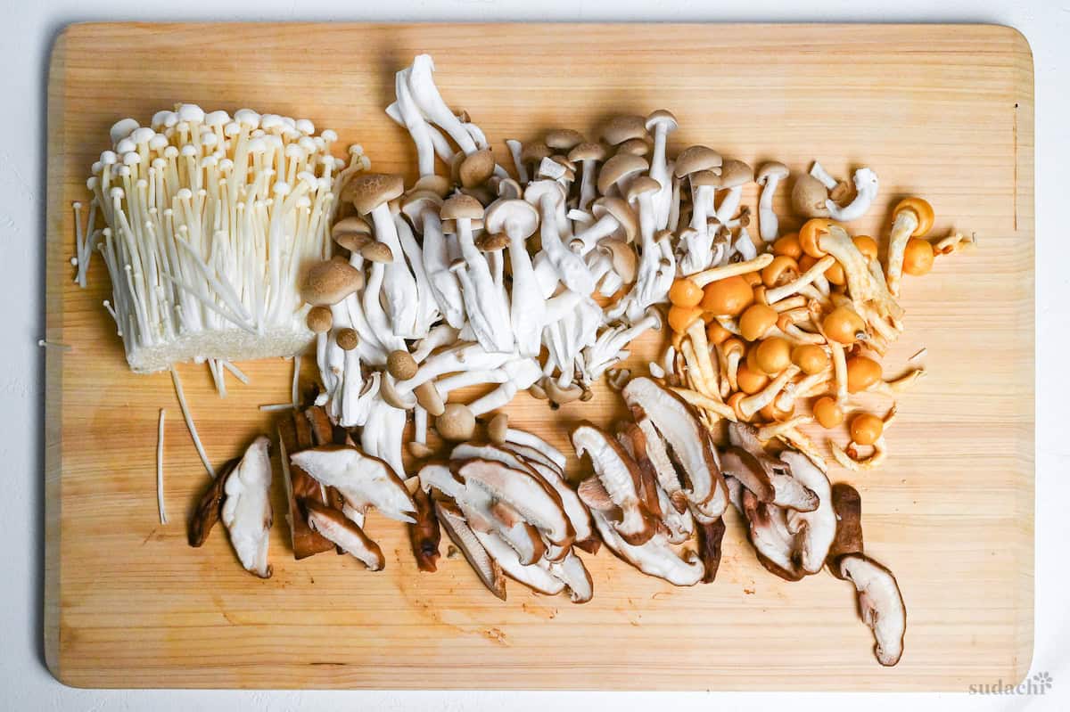 Enoki, shimeji, shiitake and nameko mushrooms on a cutting board - how to cut for mushroom miso soup