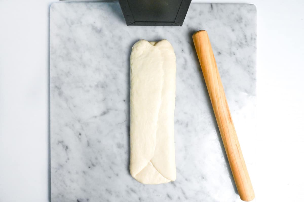 edges of shokupan dough folding over and pinched at the seam