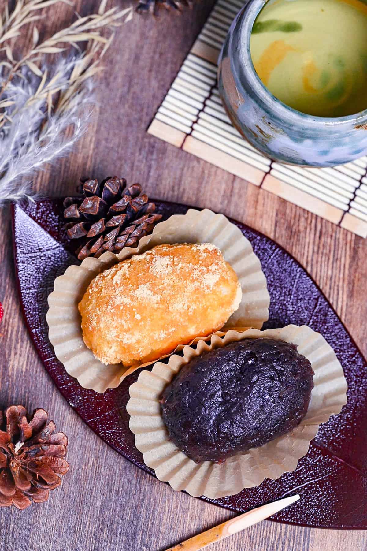 red bean and kinako ohagi on a red leaf-shaped plate with green tea