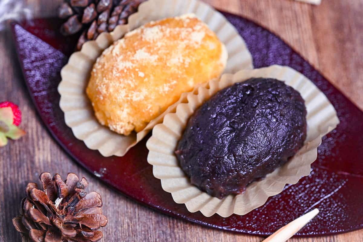 red bean and kinako ohagi on a red leaf-shaped plate with green tea