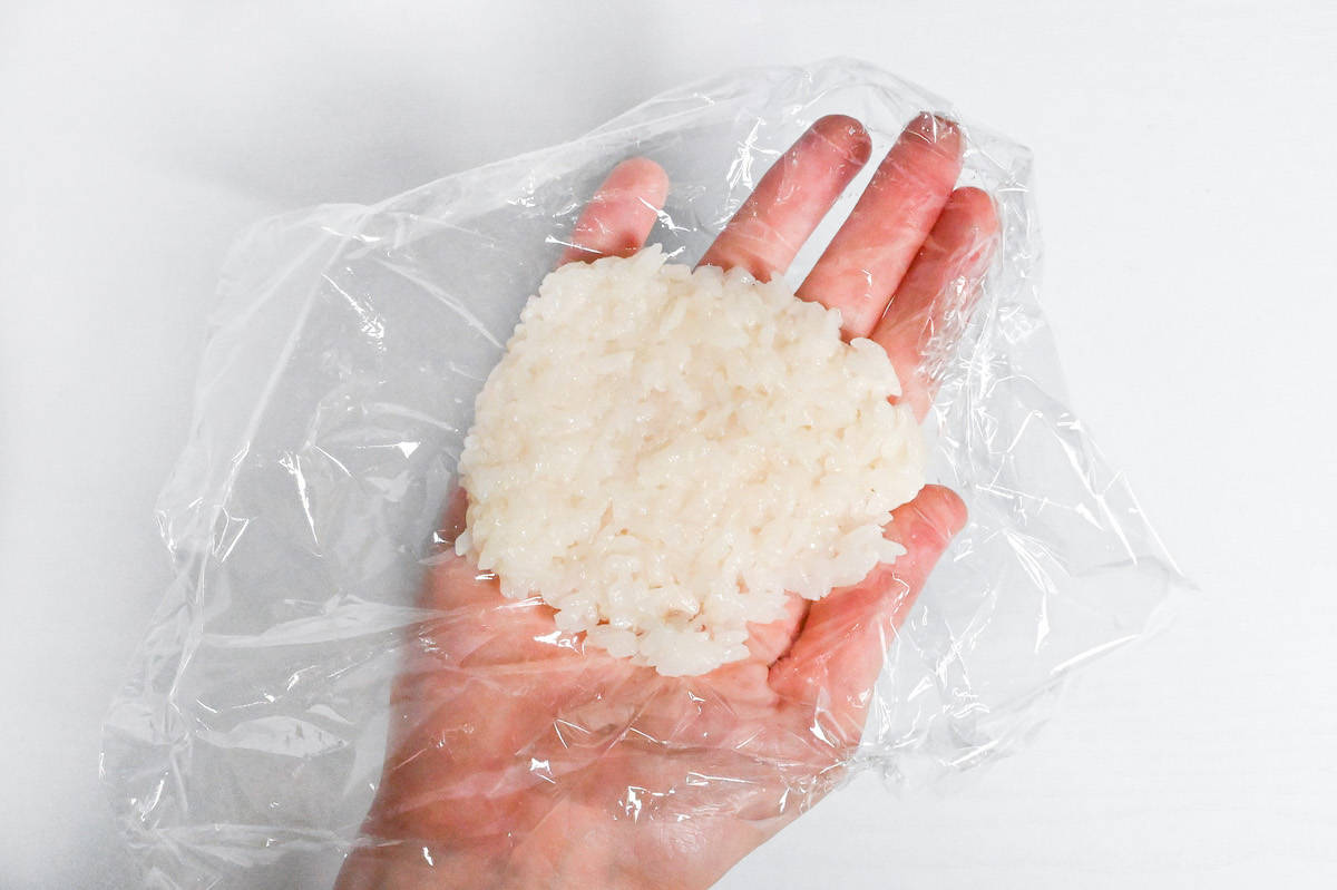 cooked mochigome pressed into a disk shape on plastic wrap