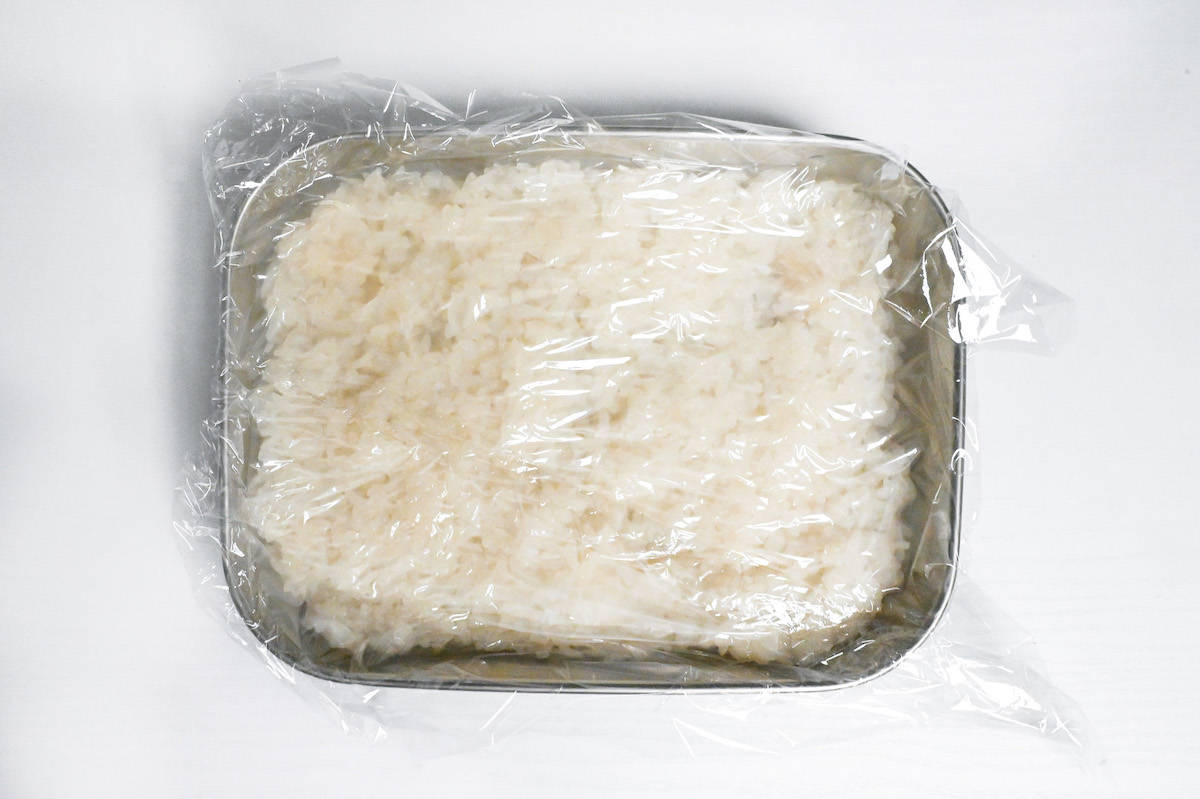 cooling cooked mochigome in a wide container covered with plastic wrap