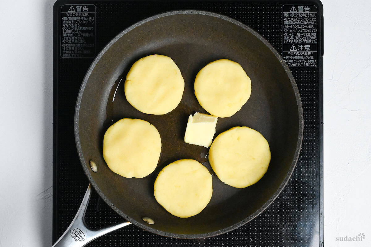 5 potato mochi in a frying pan with butter