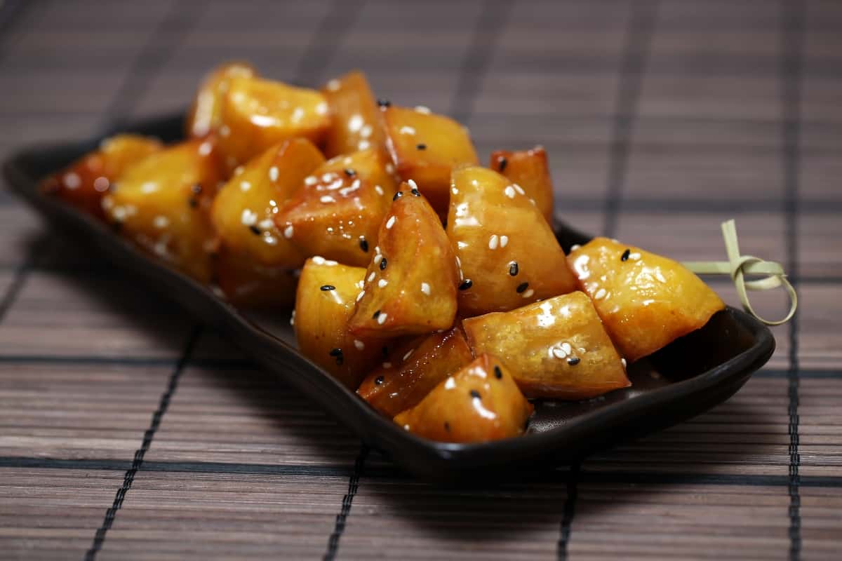 Daigaku Imo (Japanese Candied Sweet Potato) cut rangiri style on a black plate