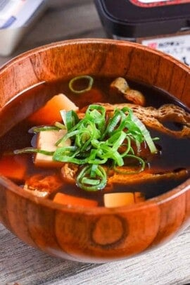 aka-dashi (red miso soup) in wooden bowl topped with chopped green onion