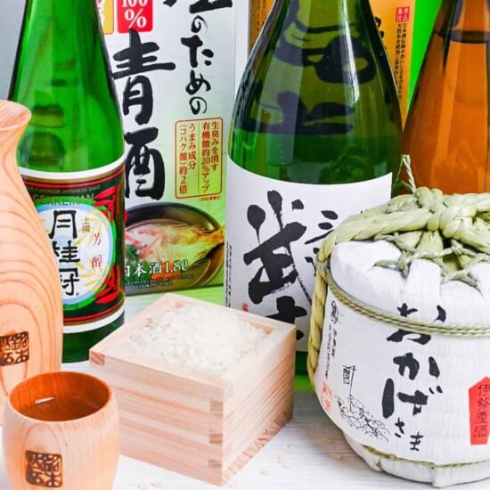 bottles of sake with a box of rice and a cup of sake