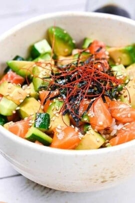 almon sashimi bowl (salmon donburi) in a white bowl topped with kizami nori and chili threads