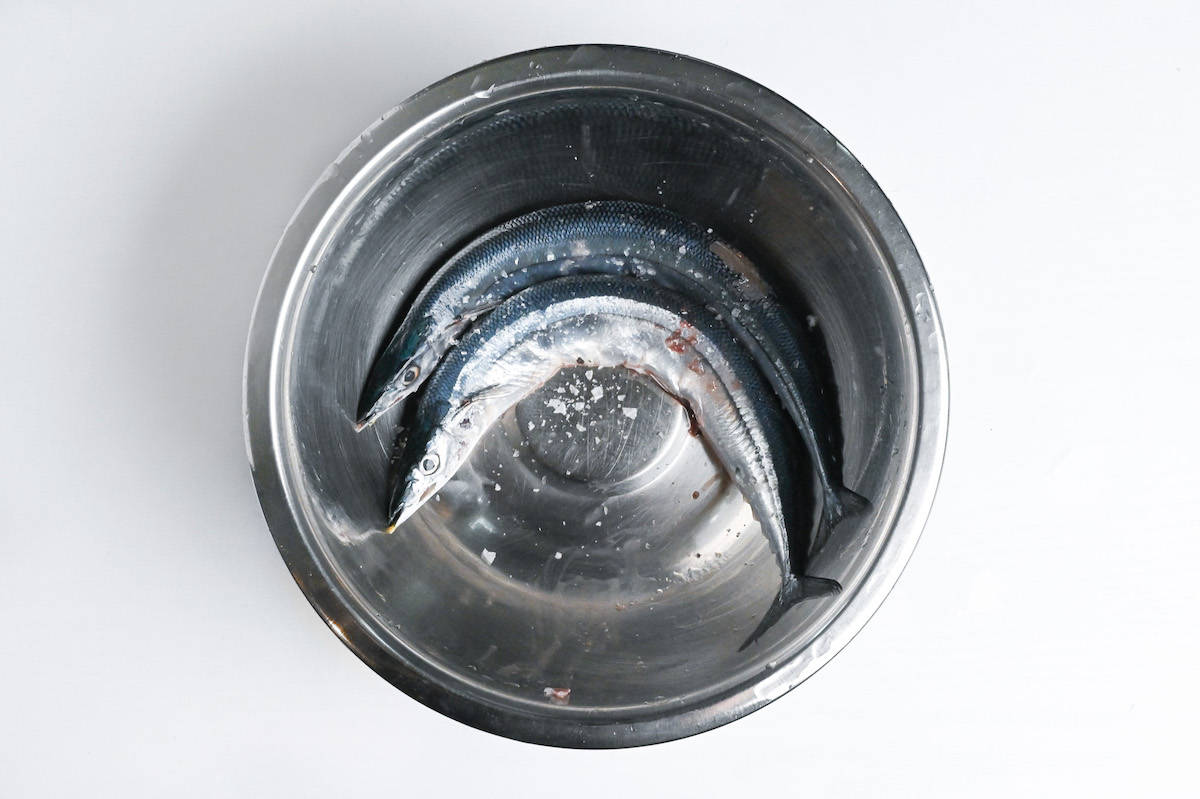 two pacific saury in a bowl with salt