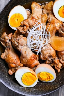 Tori no Sappari-ni made with chicken drumsticks and boiled eggs simmered in a vinegar based broth served in a black oval shaped bowl