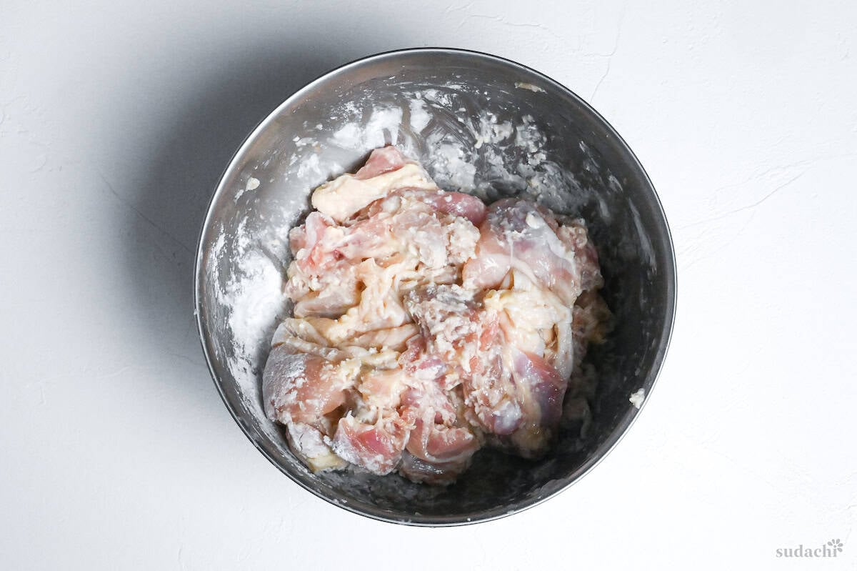 chicken thigh pieces coated with shio koji in a mixing bowl