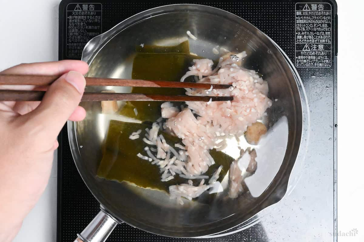 ground chicken in pot of water with kombu and scallops