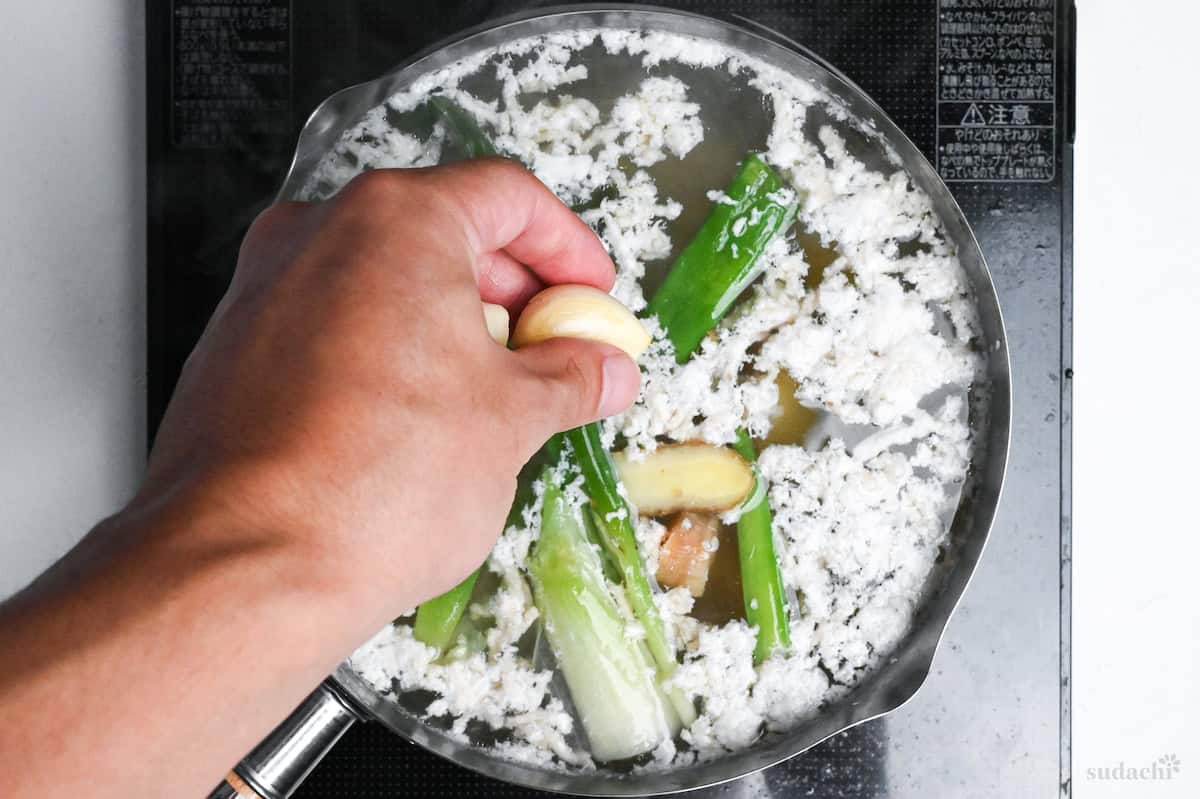 dropping garlic cloves into shio ramen broth