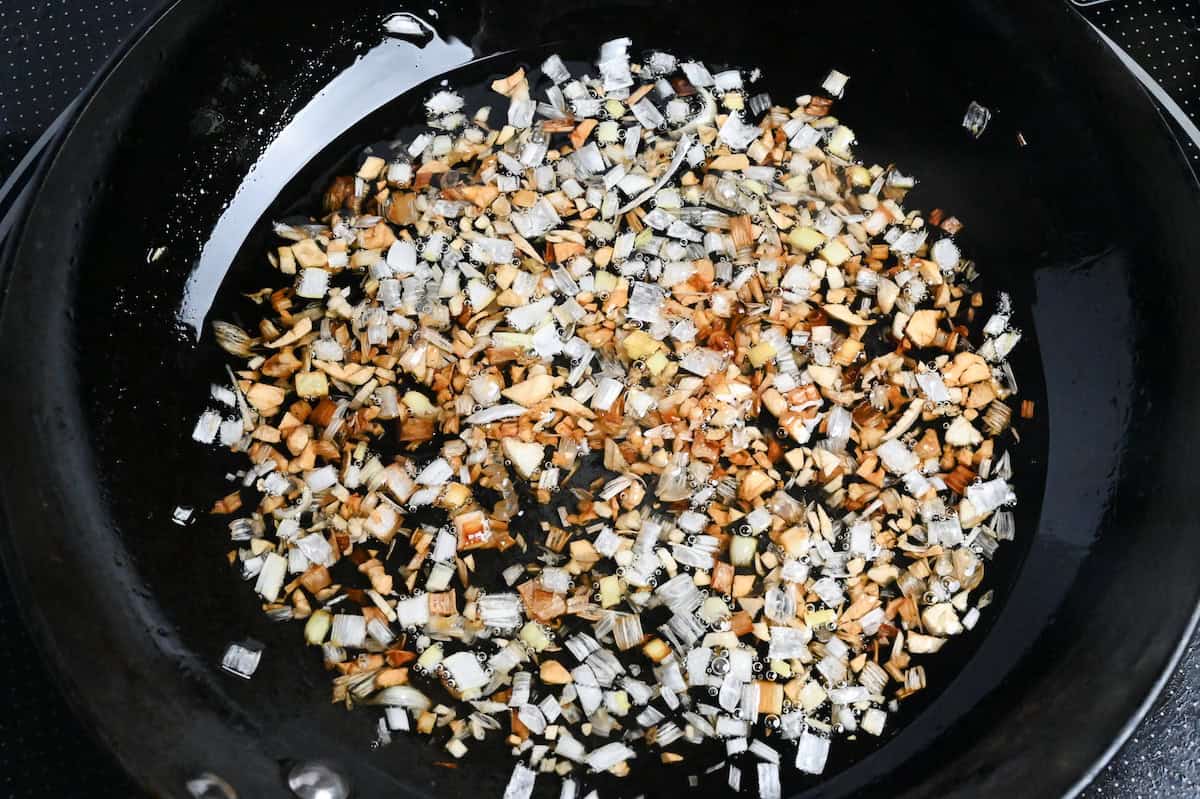 finely chopped Japanese leek (white part) frying in lard in a small frying pan