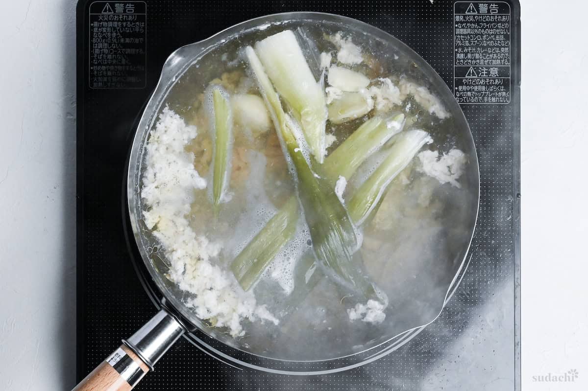 shio ramen broth simmering in a pot on the stove