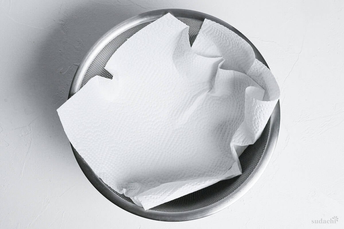 a piece of kitchen paper in a fine mesh sieve over a bowl
