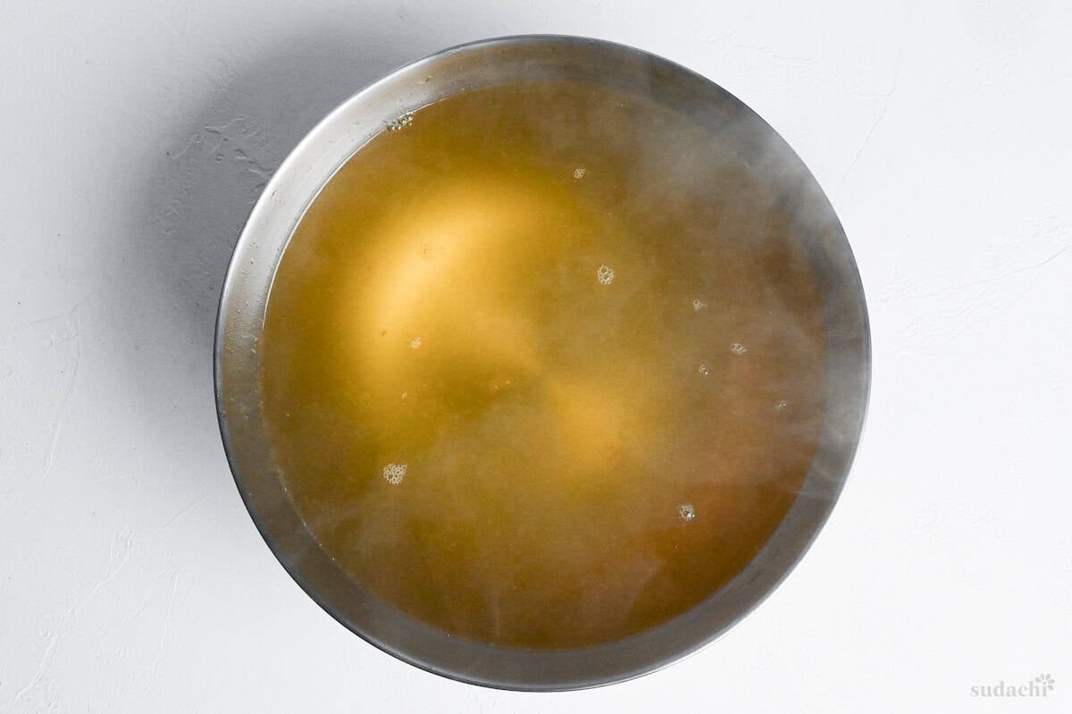 clear shio ramen broth in a heatproof mixing bowl (steel)