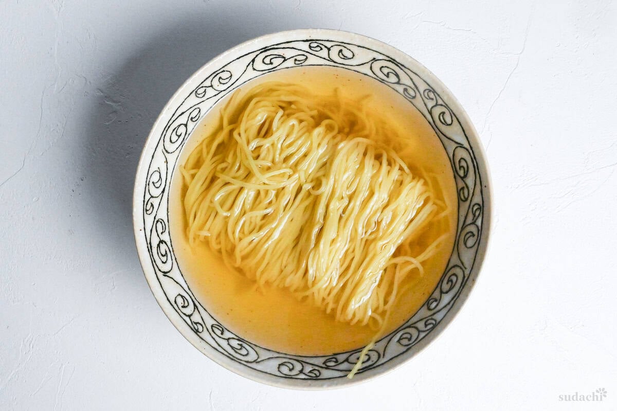 Ramen noodles in homemade shio broth in a cream bowl with black patterned rim