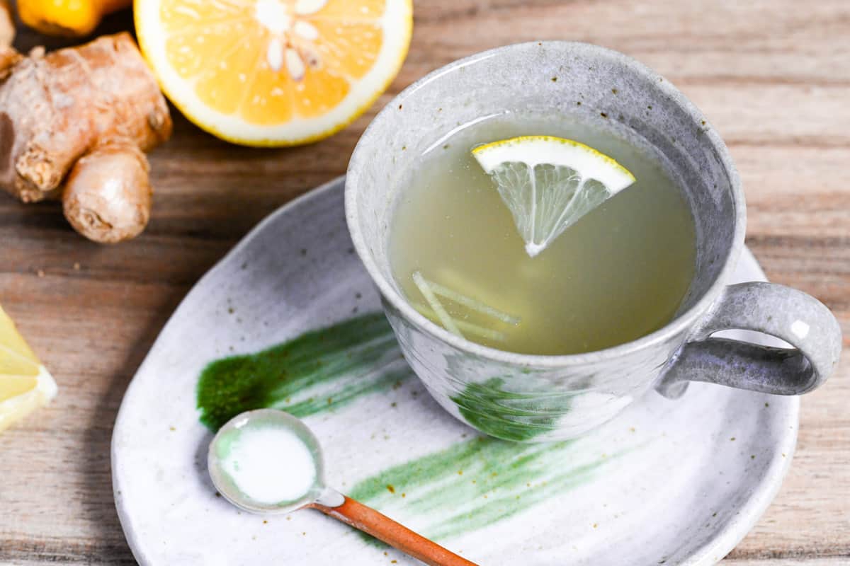 Japanese ginger tea (shogayu) in a gray cup with lemon and ginger pieces