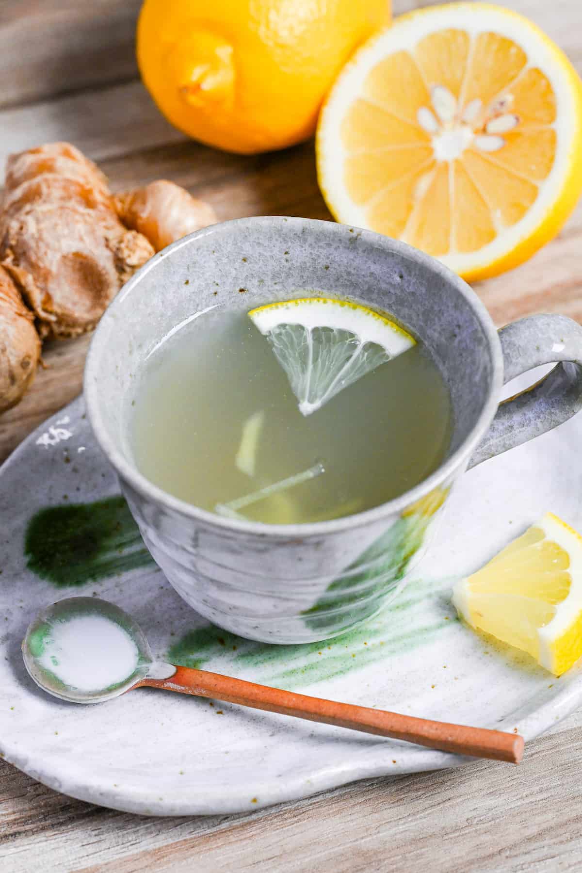 Japanese ginger tea (shogayu) in a gray cup with lemon and ginger pieces