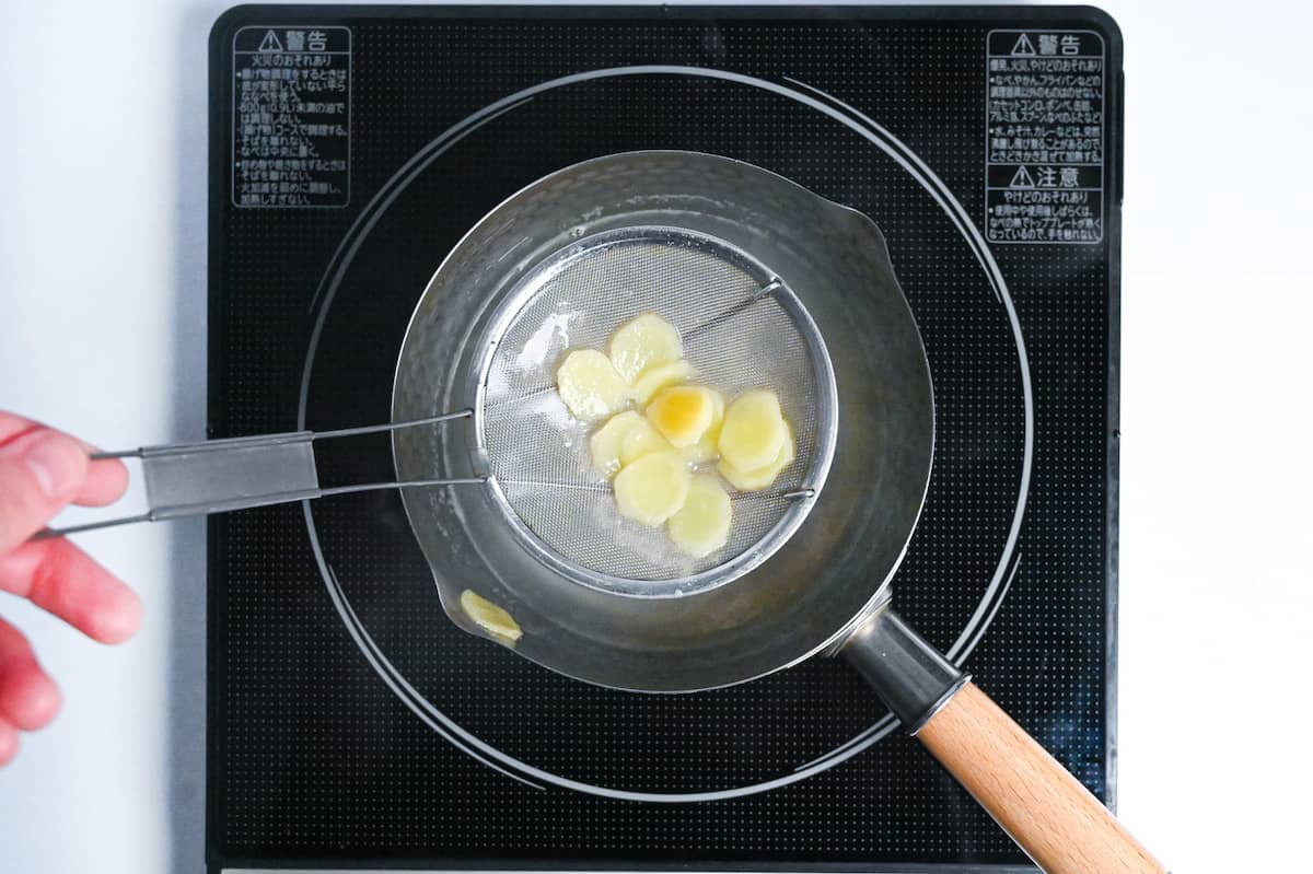 scooping ginger out of shogayu using a mesh spoon