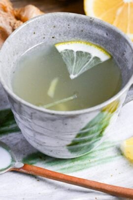 Japanese ginger tea (shogayu) in a gray cup with lemon and ginger pieces