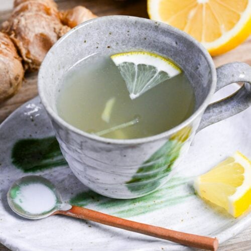 Japanese ginger tea (shogayu) in a gray cup with lemon and ginger pieces