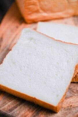 2 slices of nama shokupan on a wooden chopping board