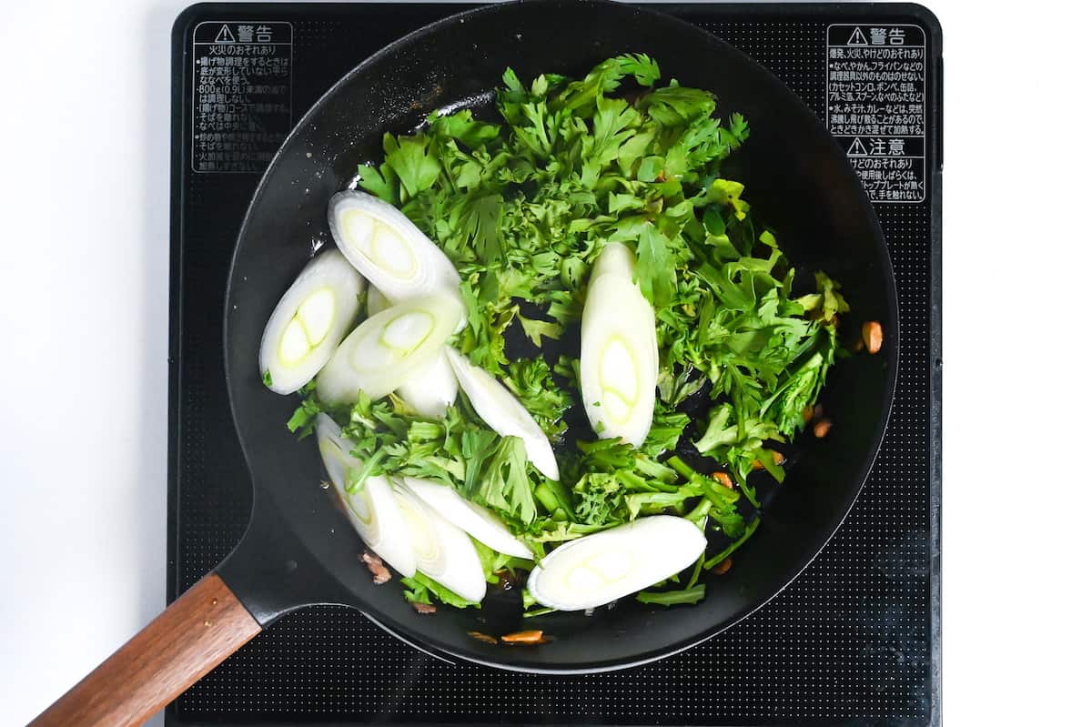 Japanese leeks and crown daisy in sukiyaki sauce in a pan