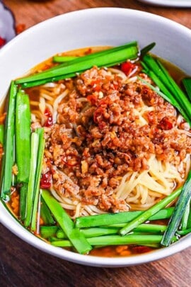 Nagoya style spicy Taiwan ramen in a white bowl, ramen noodles in a dashi based broth topped with garlic chive and spicy ground pork