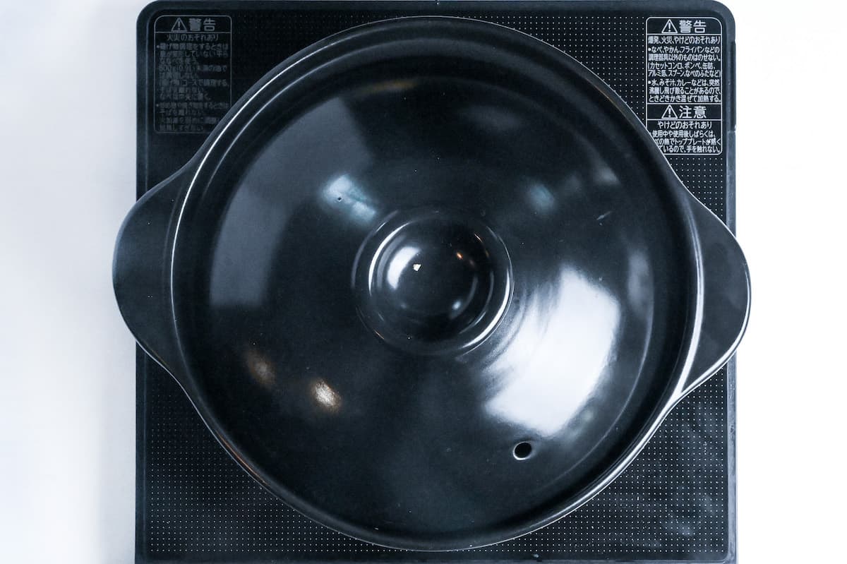 cooking chicken takikomi gohan in a pot with a lid