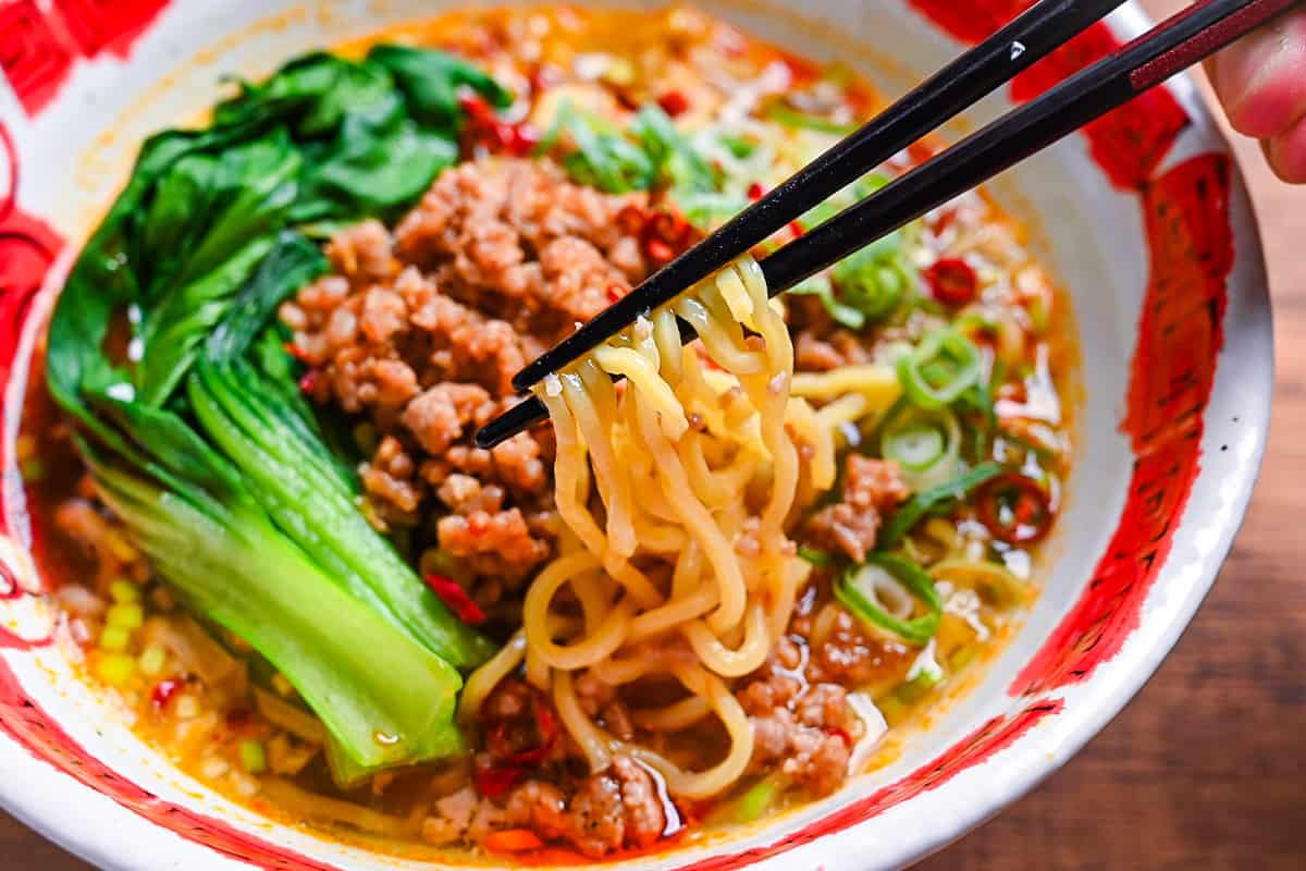 holding ramen noodles with black chopsticks (tantanmen)