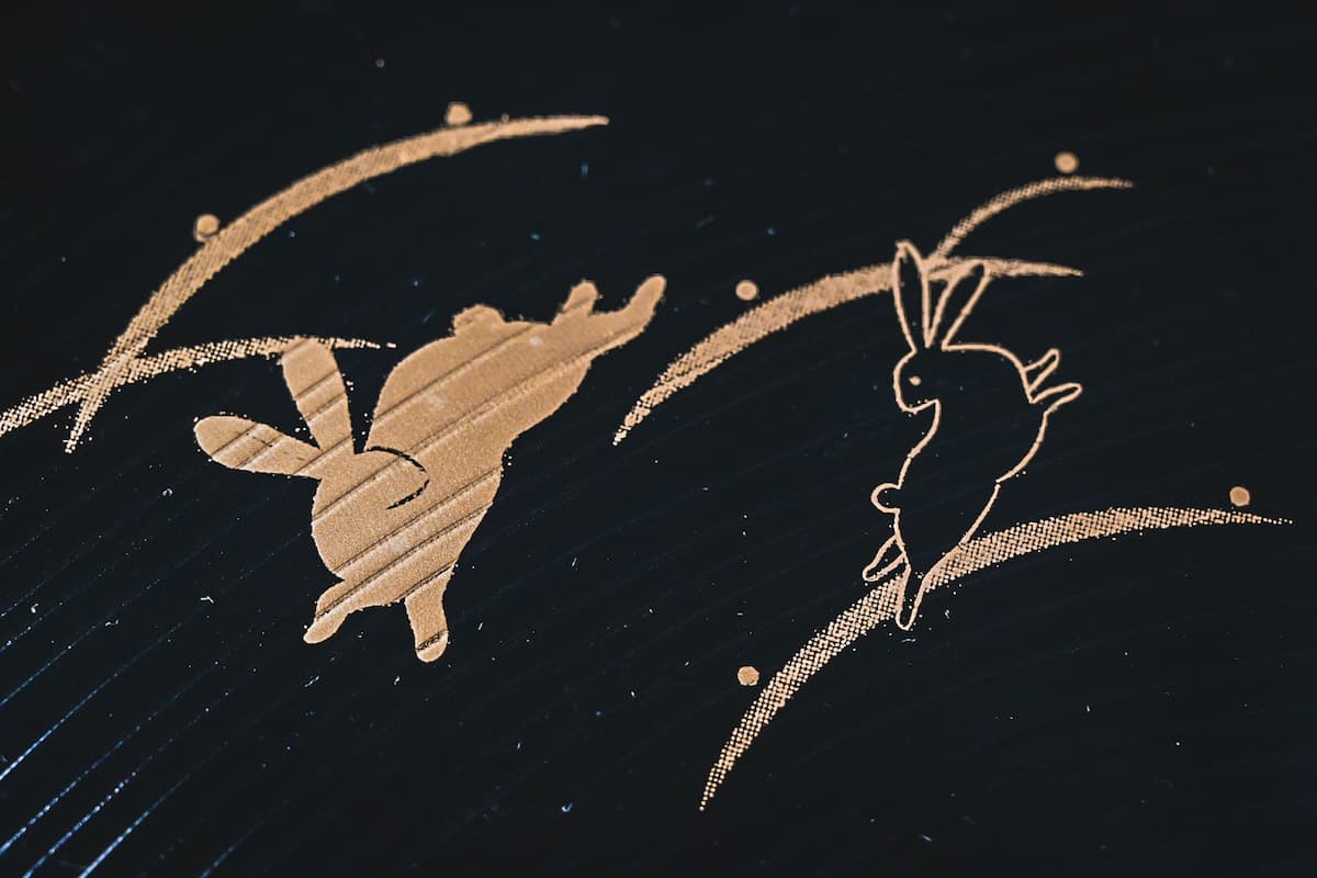 gold rabbit design on black tray