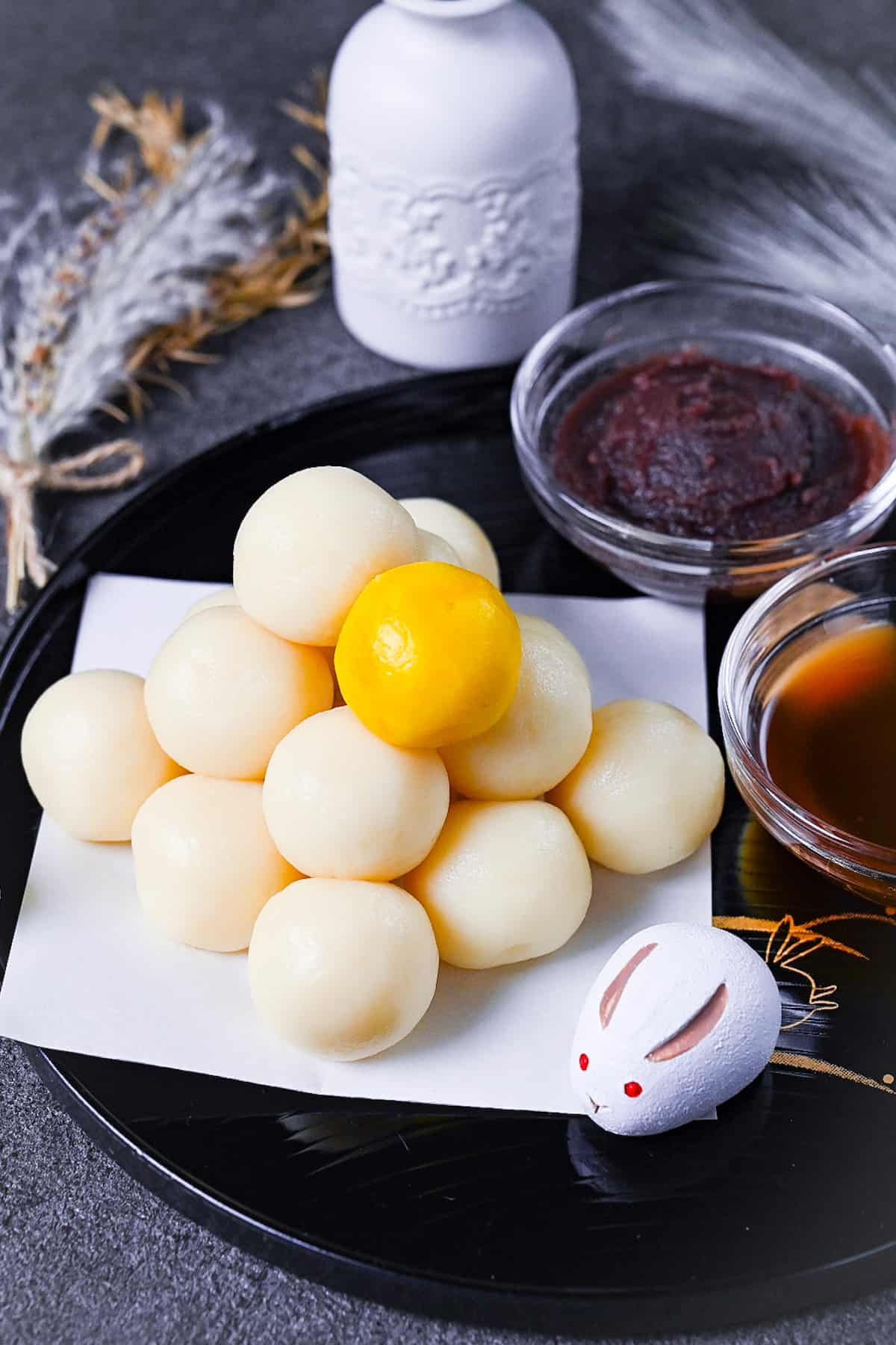 tsukimi dango moon viewing dumplings on a black tray decorated with gold rabbits