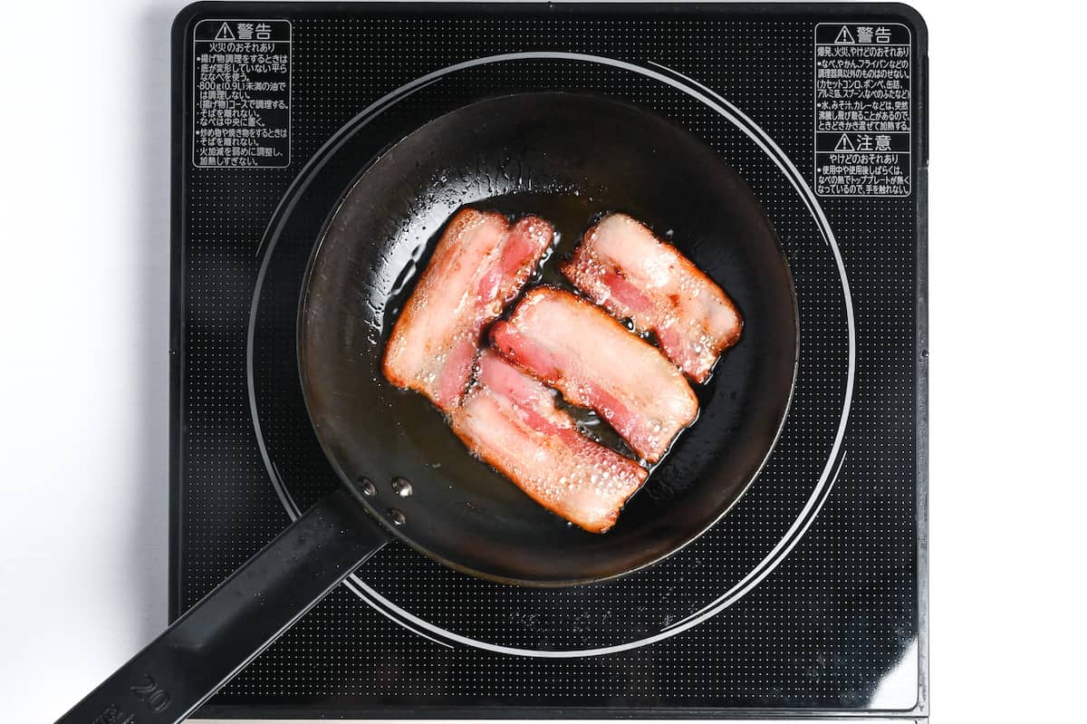 frying 4 pieces of bacon in a pan