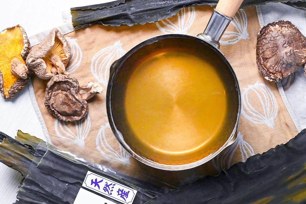 Vegan awase dashi made with kombu dried kelp and shiitake mushrooms in a steel pot