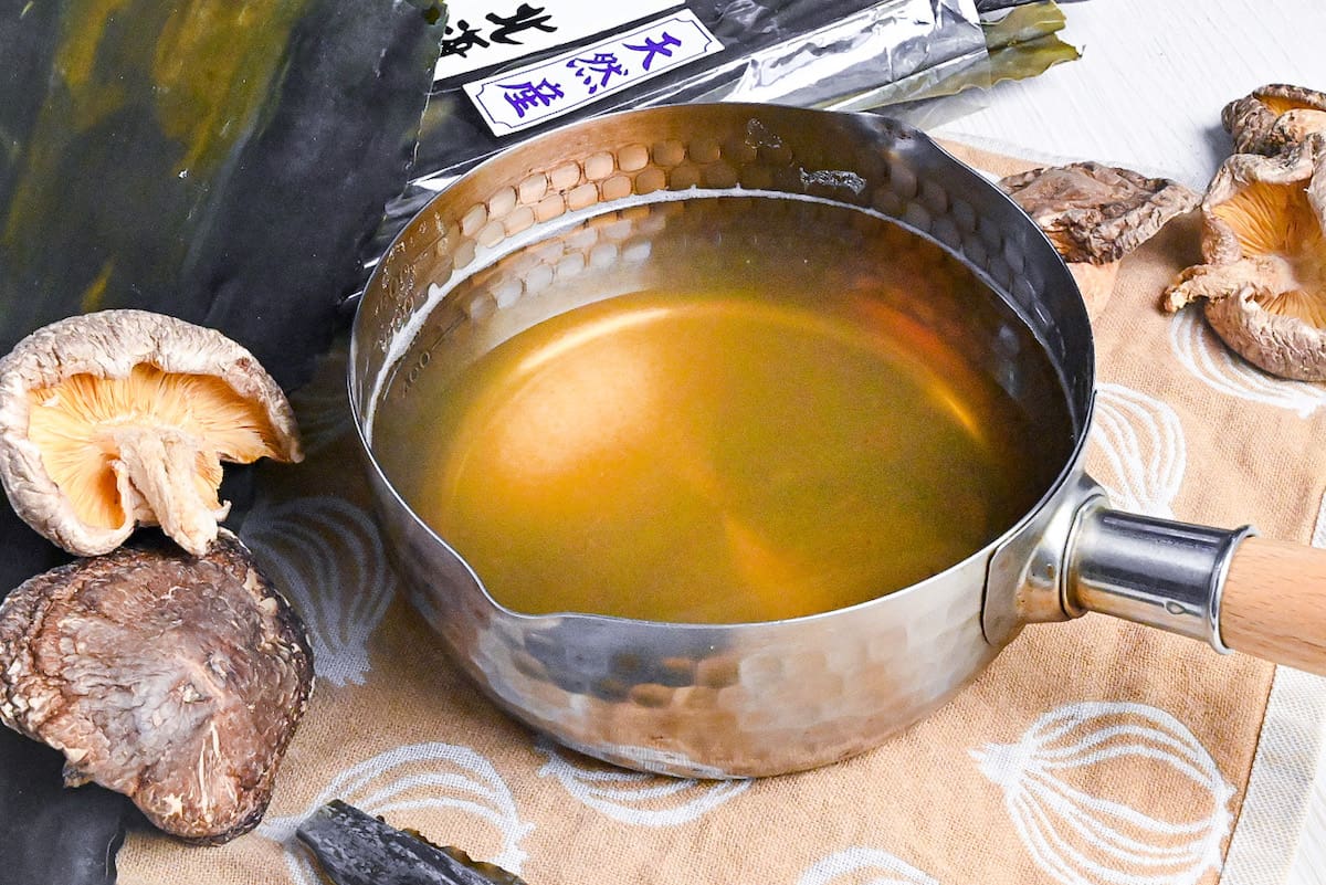 Vegan awase dashi made with kombu dried kelp and shiitake mushrooms in a steel pot