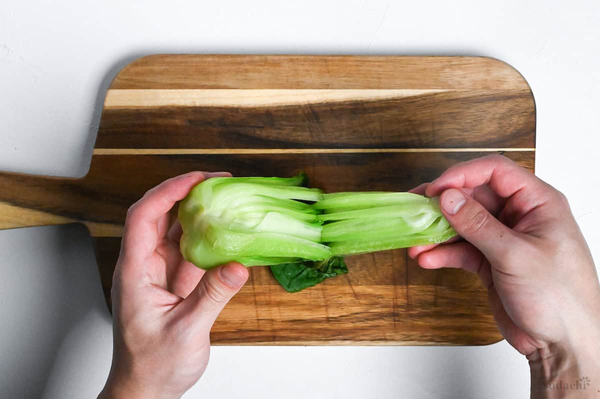 peeling apart the leaves of cooked bok choy