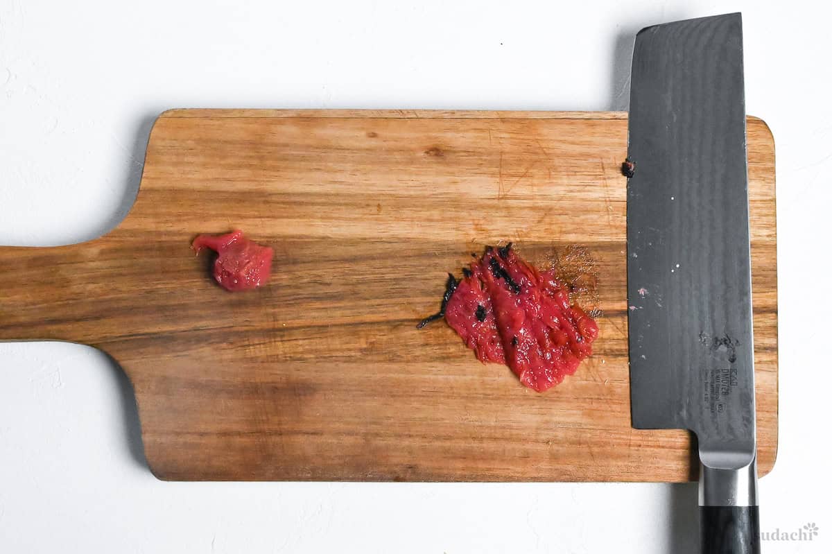 umeboshi pasted on a wooden chopping board with seed removed
