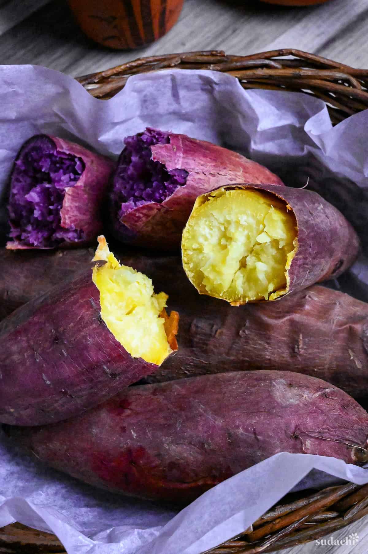 Yaki imo (baked Japanese sweet potatoes) in a woven basket lined with paper and surrounded by pinecones and maple leaves